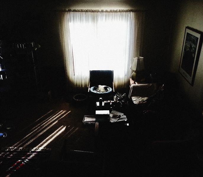 Dark room, with slight light gleaming through window during power outage.