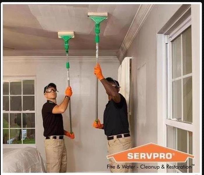 SERVPRO Technicians cleaning up soot on the ceiling.