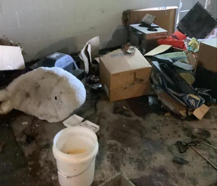 Damaged box's and debris in basement from sewage flood